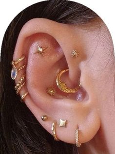 a woman wearing gold ear piercings with stars and moon designs