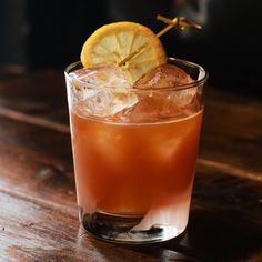 a close up of a drink on a table with a slice of lemon in it