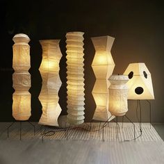 three lamps are sitting on top of each other in front of a black wall and floor