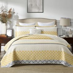 a bed with yellow and white bedspread in a room