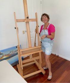 a woman is standing next to an easel