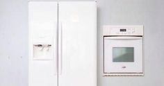 a white refrigerator freezer sitting next to a wall mounted appliance in a kitchen