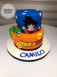 a birthday cake with a dragon on the top and name written in blue, orange and yellow