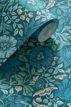 a blue and green wallpaper with flowers on it