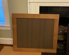 a wooden frame sitting on top of a table next to a fireplace in a living room