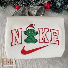 Introducing the Baby Grinch Christmas Nike Embroidered Sweatshirt, the perfect Christmas gift for couples! This cozy and stylish sweatshirt is designed with meticulous attention to detail, featuring a cute Baby Grinch graphic embroidered on the front. Made with premium quality materials, it offers ultimate comfort and durability. Not only does this sweatshirt keep you warm [...] Nike Iron On Grinch Sweatshirts, Nike Embroidery Christmas Sweatshirt, Christmas Crewneck Nike, Grinch Nike Embroidery, Custom Christmas Nike Sweatshirt, Grinch Nike Hoodie, Nike Christmas Crewneck, Christmas Nike, Nike Embroidered Sweatshirt