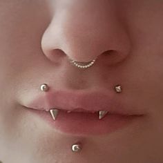 a woman with three piercings on her nose