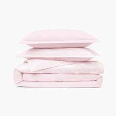 the pink sheets and pillow cases are stacked on top of each other in front of a white background