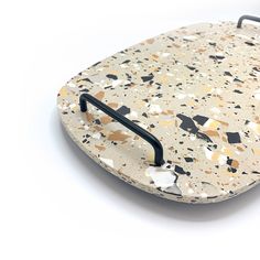 a white and black surfboard sitting on top of a white surface with speckles