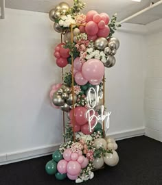 the balloon column is decorated with flowers and balloons for baby's first birthday party