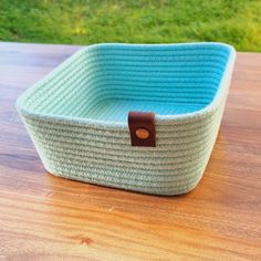 a blue basket sitting on top of a wooden table