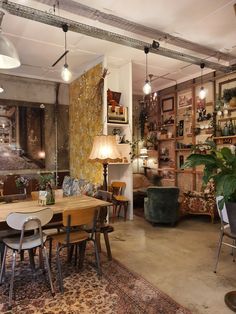 a living room filled with furniture and lots of plants on top of a wooden table