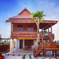 a wooden house sitting on top of a lush green field