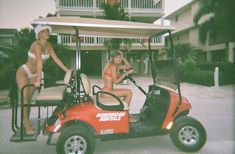 two women in bikinis are on a golf cart