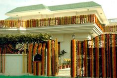 a large white house with an orange and yellow striped fence