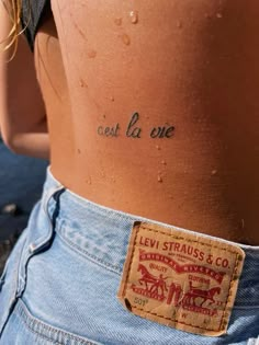 the back of a woman's stomach with words written on her left arm and chest