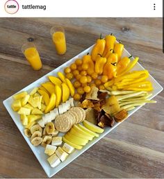 a white plate topped with different types of fruits and vegetables next to glasses of orange juice