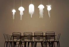 a dining room table with chairs and lights hanging above it