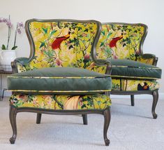 two green velvet chairs with floral designs on them