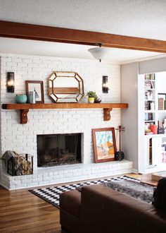 a living room filled with furniture and a fire place in front of a white brick fireplace