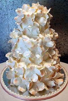 a three tiered cake with white flowers on it