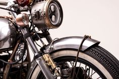 the front end of an old motorcycle with chrome paint and black spokes on it