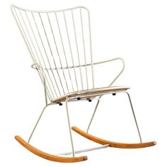 a white rocking chair with wooden slats