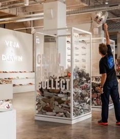 a man standing next to a display case filled with shoes