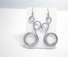 "Big aluminum wire wrapped earrings for women. Wire wrapped 100% hand made earring in aluminum wire. Silver color.  Big but light weight earrings.  Total length about 7 cm (2.8 inch), max width about 2.8 cm (1.1 inch). These earrings are made with 12 ga (2 mm,  0.081 inch) aluminium wire. Note that the earrings you'll receive could be a little different than those in the picture, because they are made by hand. Also size could vary a little bit. If you like big dangling earrings, these are right for you! ❤ PROCESSING TIME:  See below in the \"Shipping and Returns\" section. ❤ ESTIMATED SHIPPING TIME:  -Italy: 1-4 business days with POSTA1 (tracked), upgrade to RACCOMANDATA1 available in the shopping cart -North America: 2-5 weeks,  tracked shipping  -Europe: 3-21 business days, tracked ship Aluminum Wire Jewelry, Aluminum Earrings, Aluminum Jewelry, Bijoux Fil Aluminium, Peacock Earrings, Earrings Big, Wrapped Earrings, Bold Earrings, Spiral Earrings