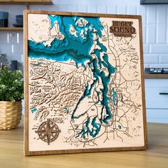 a wooden block with a map of the lake and surrounding it on a kitchen counter