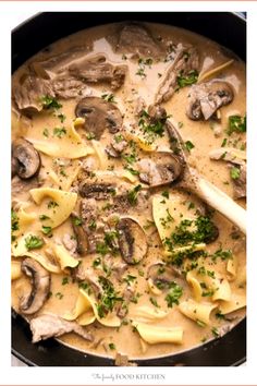 a skillet filled with pasta, mushrooms and parsley in a creamy broth sauce