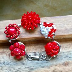 "This is a lovely up cycled bracelet that I created by repurposing vintage 1950- 1960's  clip on / screw back earrings. There is 5 earrings in shades of red. The earrings have been affixed onto an antique silver 18 mm blank bracelet setting. The length of the bracelet is adjustable from 7\" - 8\". Contact me if you need a custom size." Vintage Adjustable Red Bracelets, Vintage Red Adjustable Bracelets, Vintage Red Adjustable Bracelet, Vintage Red Bracelet As A Gift, Vintage Red Bracelet For Gifts, Retro Red Bracelet Jewelry, Mid-century Red Jewelry For Gift, Vintage Red Jewelry, Mid Century Glam