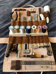 an assortment of sewing supplies laid out on a bed