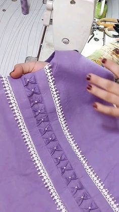 a woman is working on a purple dress