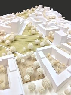 a model of a city with trees and buildings on it's sides, all in white