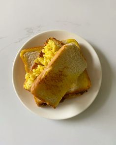 two pieces of toast with scrambled eggs on them