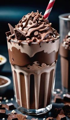 two glasses filled with chocolate milkshakes on top of a table