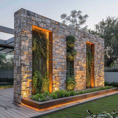 an outdoor living area with stone walls and plants growing on the wall, along with wooden decking