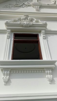 an open window on the side of a white building