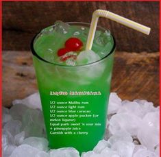 a green drink sitting on top of ice with a red and white straw in it