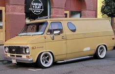 an old yellow van parked in front of a building