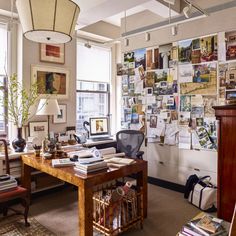 an office with lots of pictures on the wall and a desk in front of it