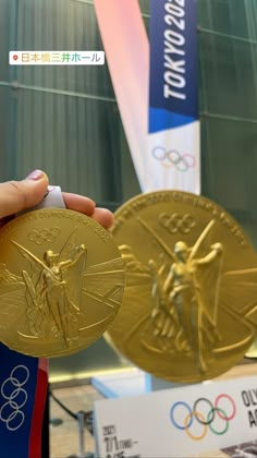 the olympic medals are being held by someone