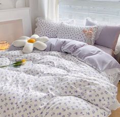 a bed with two stuffed animals on it's head and pillows in the background