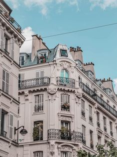 an apartment building with balconies and balconyes on the top floor, against a cloudy blue sky