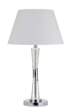 a table lamp with a white shade on the base and a silver metal frame around it