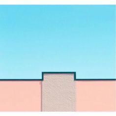 a pink building with a blue sky in the background