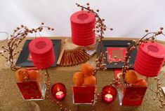 red candles and vases are sitting on a table