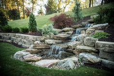 an outdoor waterfall in the middle of a garden