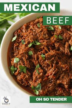 mexican shredded beef in a white bowl with cilantro garnish